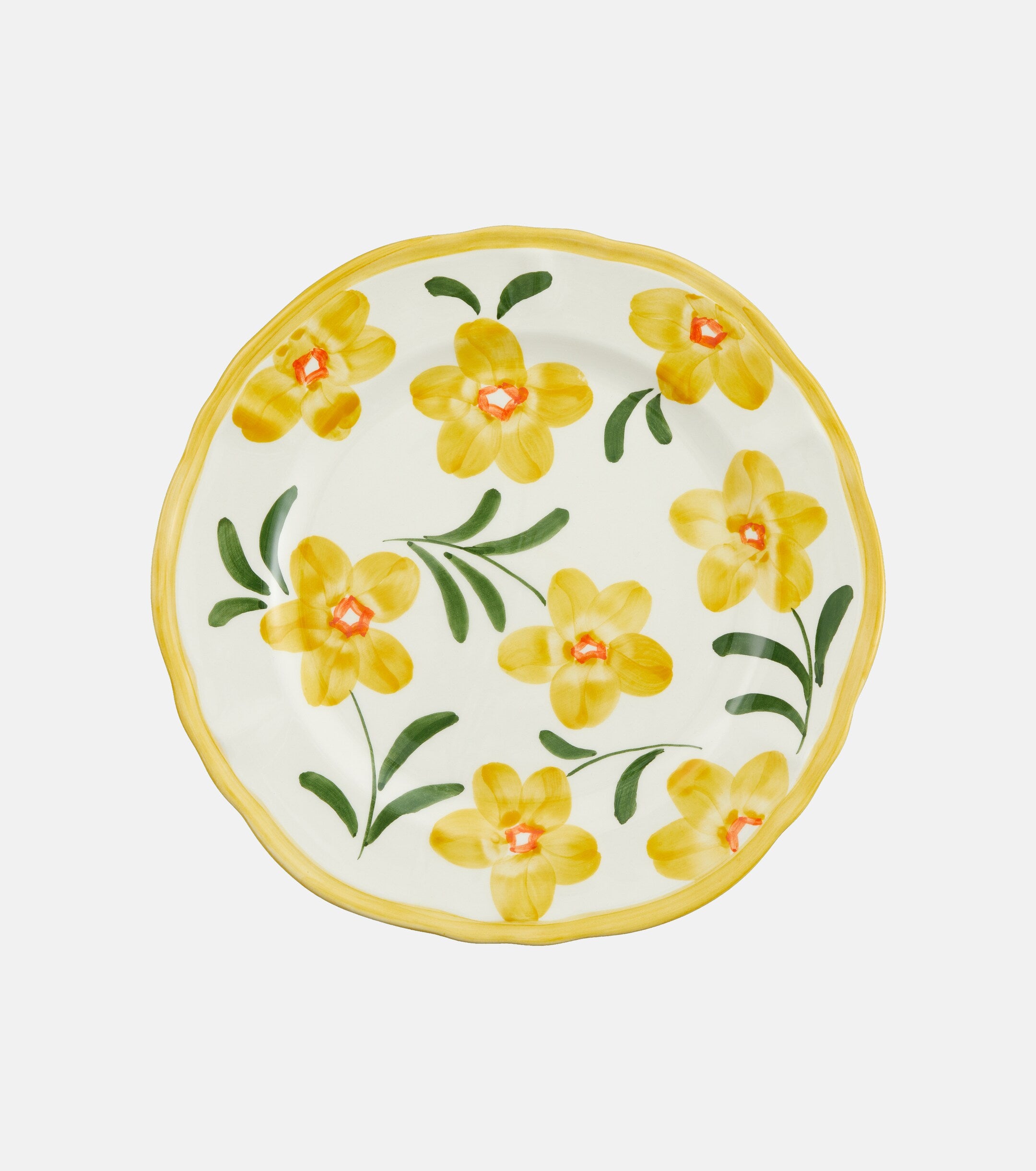 A white ceramic plate decorated with hand painted yellow flowers and finishes with a yellow rim.
