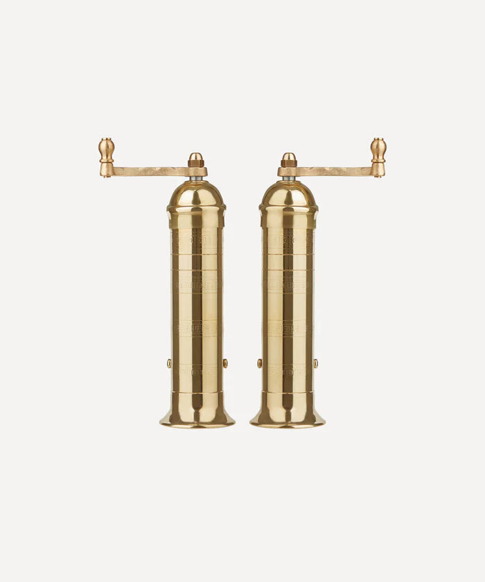 THis is a picture of Brass salt & pepper mills with a top handle standing side by side. 