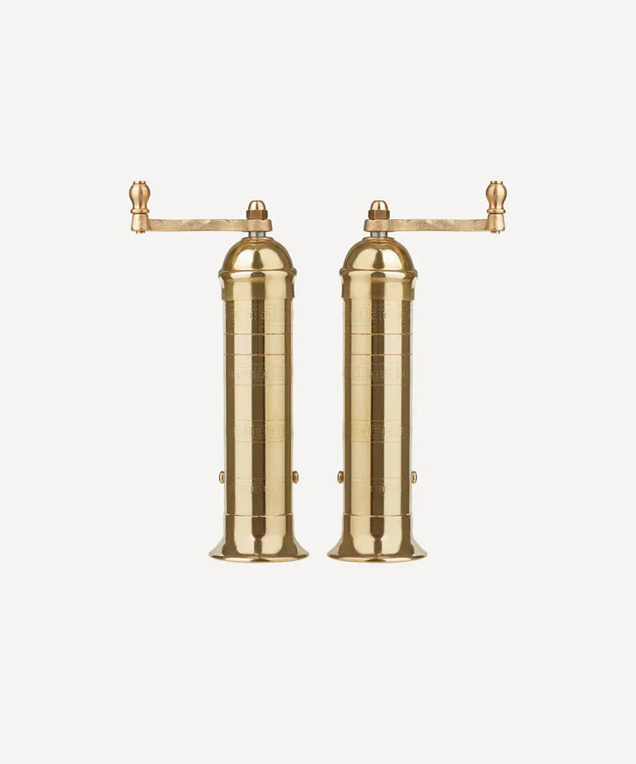 This is a picture of a set of handmade Brass salt & pepper mills from Greece, with a top handle standing side by side. 