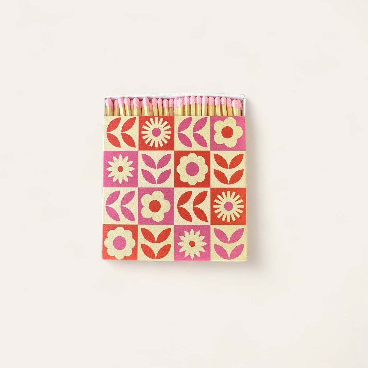 A box of luxury large matches with a pink matchhead in a pink and orange floral patterned box. 