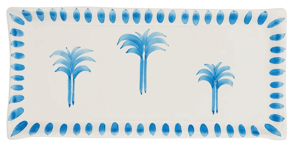 A rectangular ceramic plate with three palm trees painted in the centre in a bring blue. The rim is bright blue large dots.