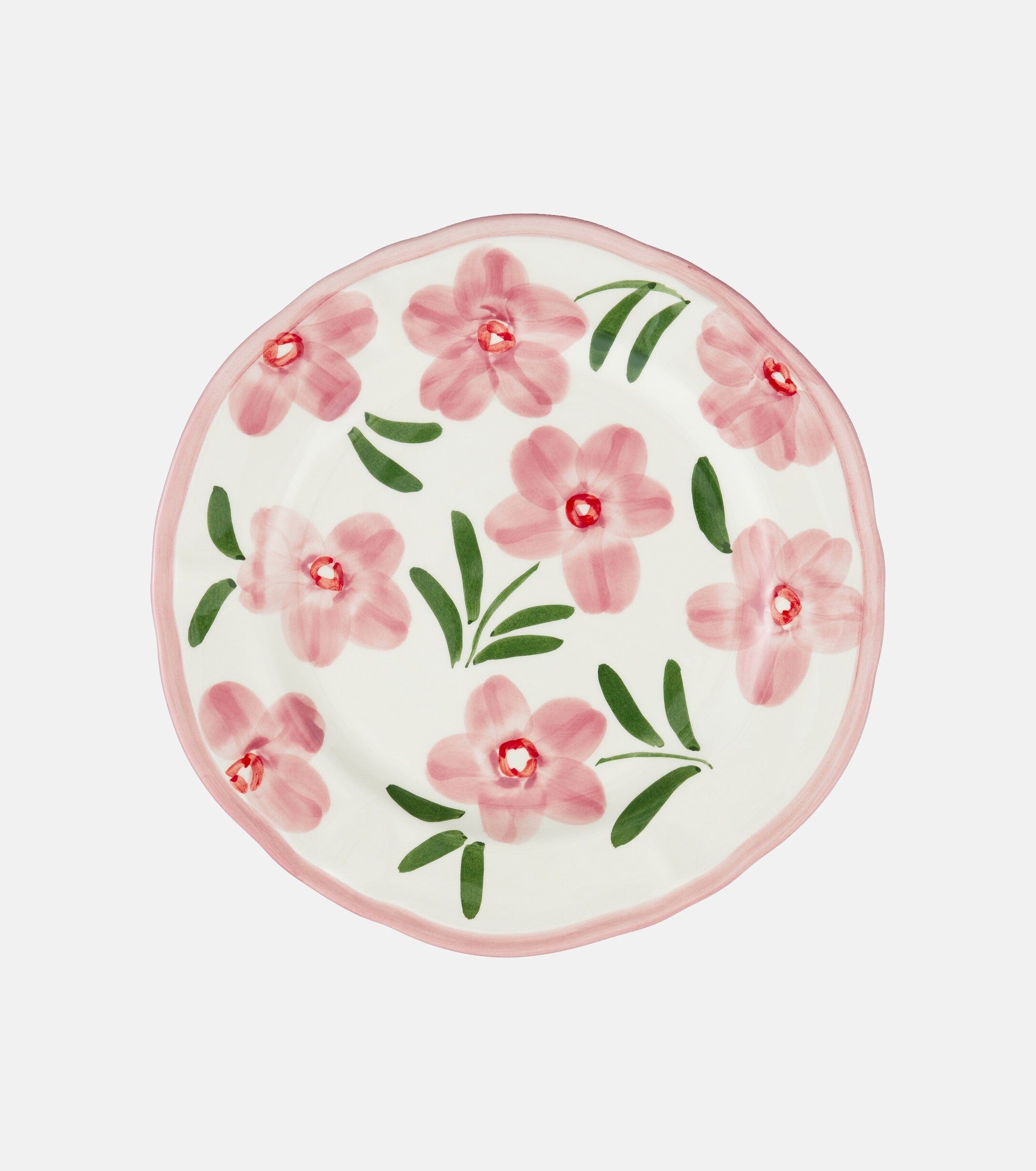 A ceramic round plate that is decorated with handpainted pink flowers and finished with a pink rim.