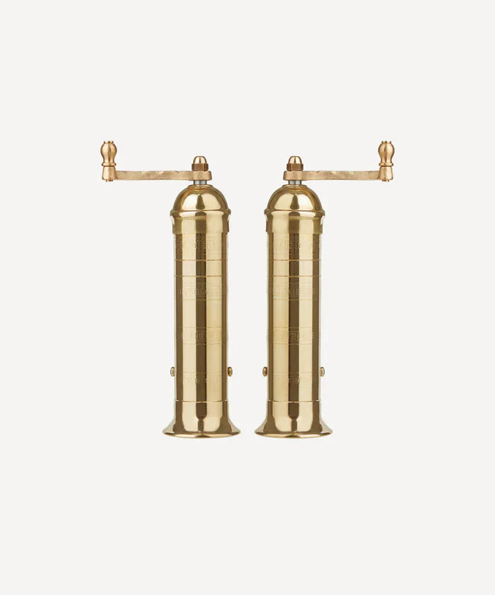 Brass salt & pepper mills with a top handle standing side by side. 