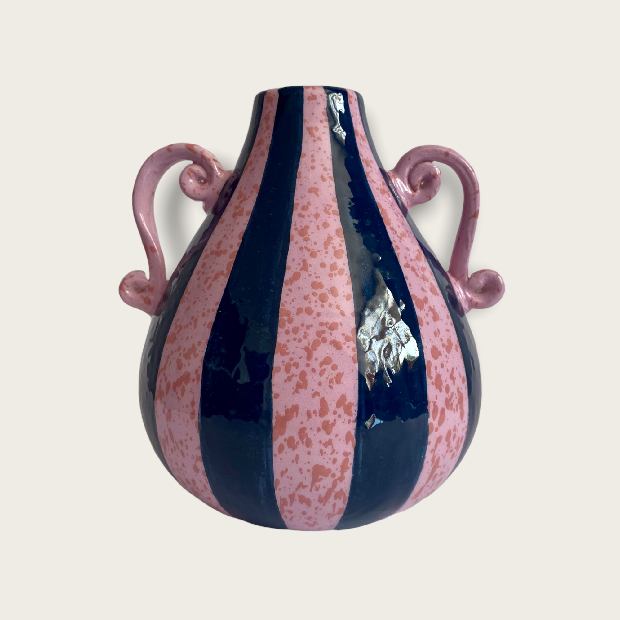 A blue and purple striped vase with speckles and two ornate handles.